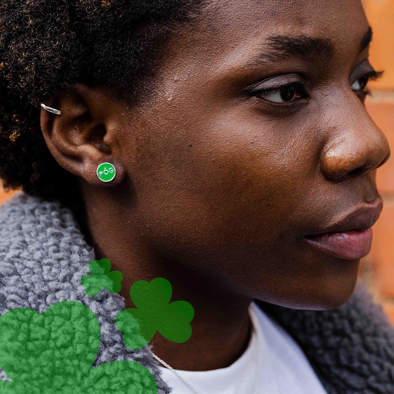 A lady wear a green pog stud and ear cuff
