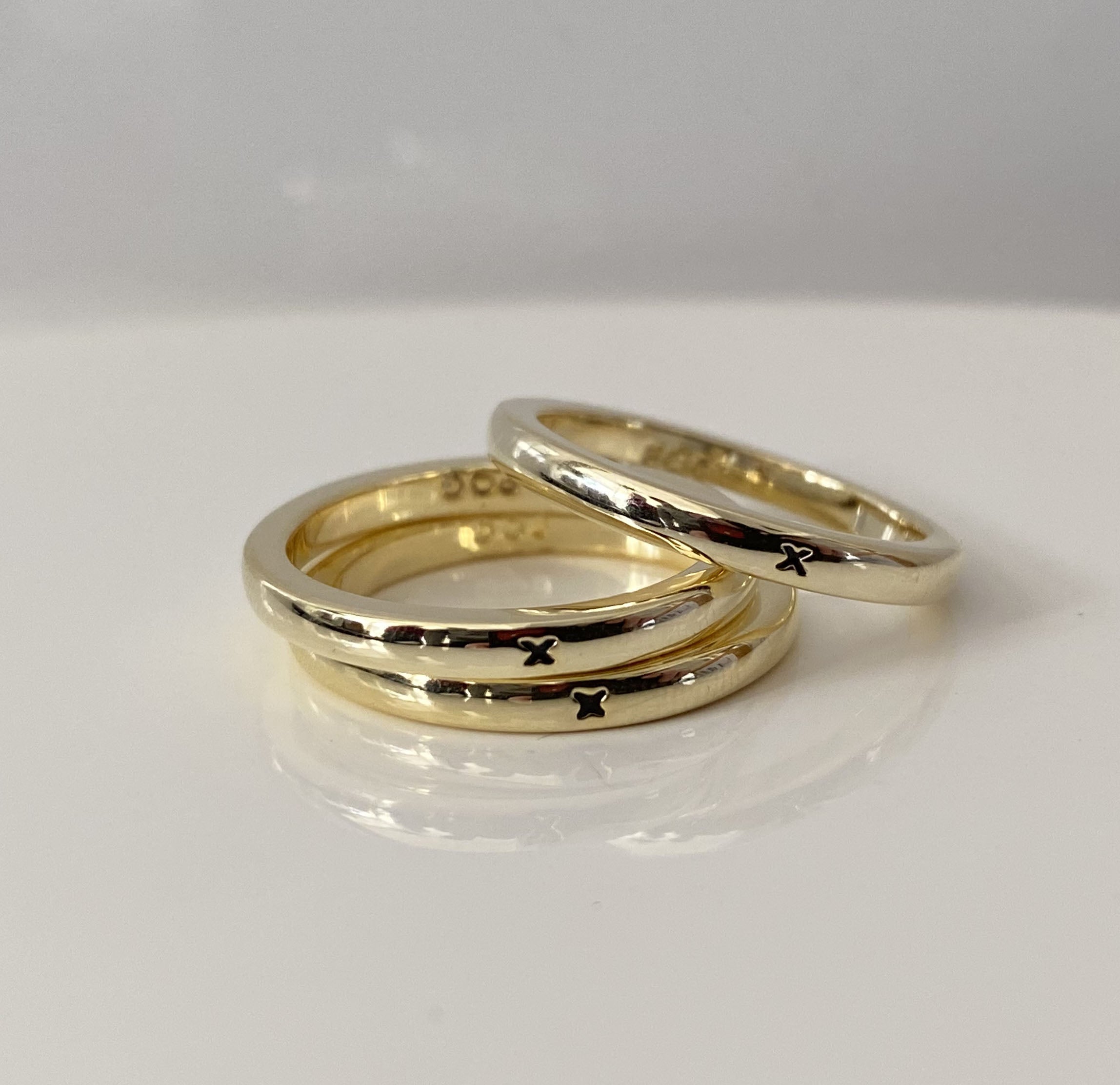 Anillo apilable de oro con una pequeña X