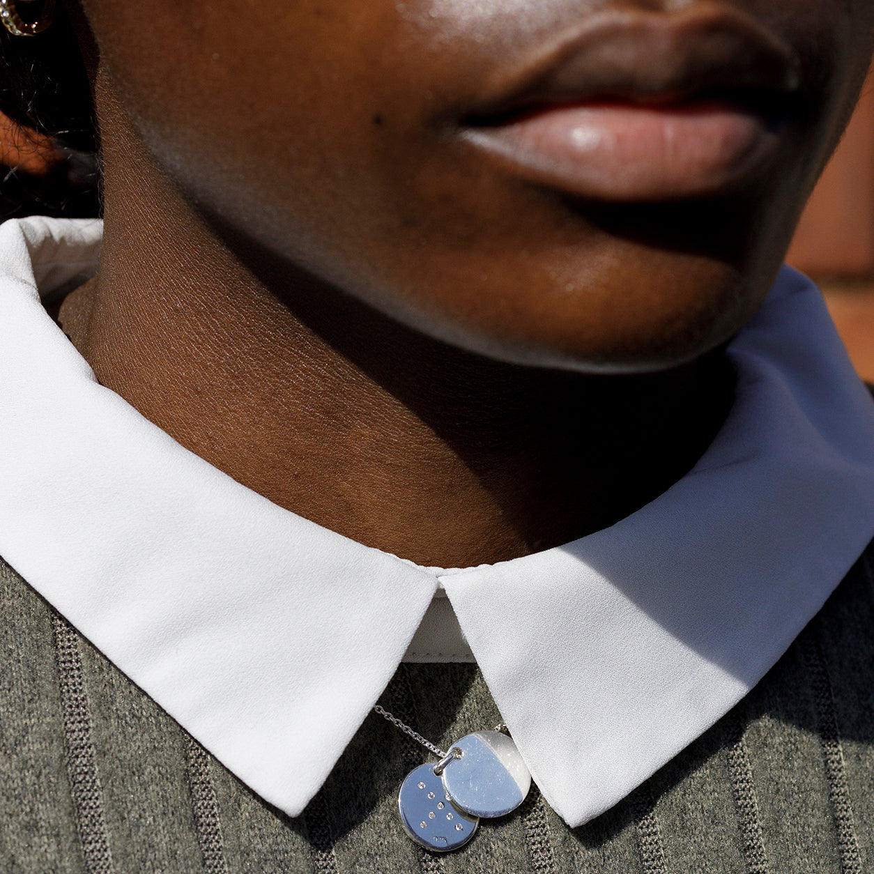 shine-fidget-locket-silver-shirt-collar-peek-view